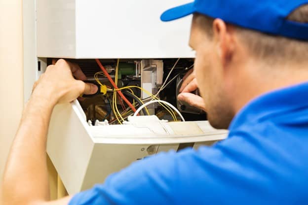 a man wearing blue polo shirt fixing boiler