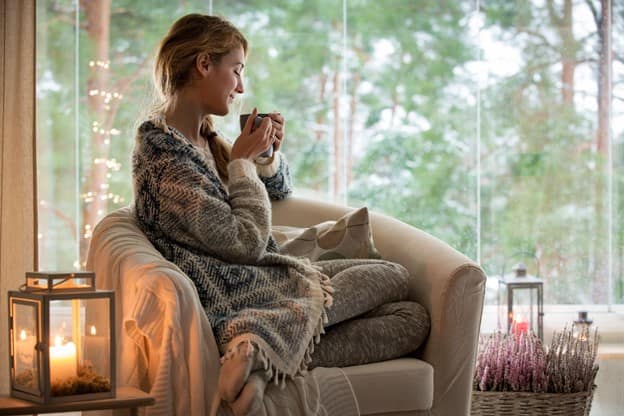 Attractive woman sitting on the sofa while drinking hot coffee