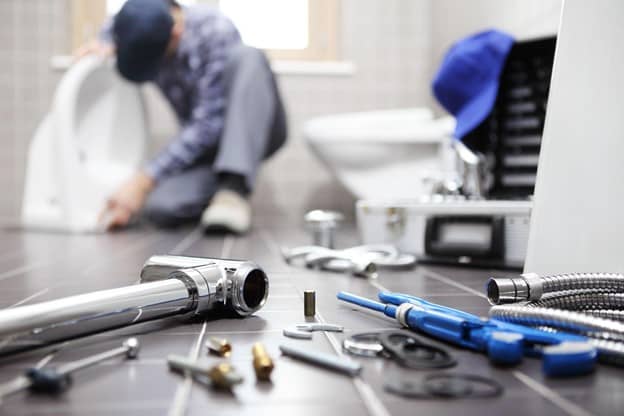 a plumber fixing the toilet